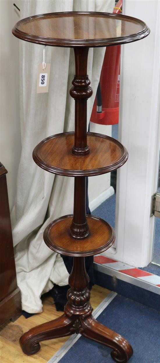A late Victorian mahogany three tier dumb waiter, on turned partly reeded support, on scrolled tripod base, H.110cm